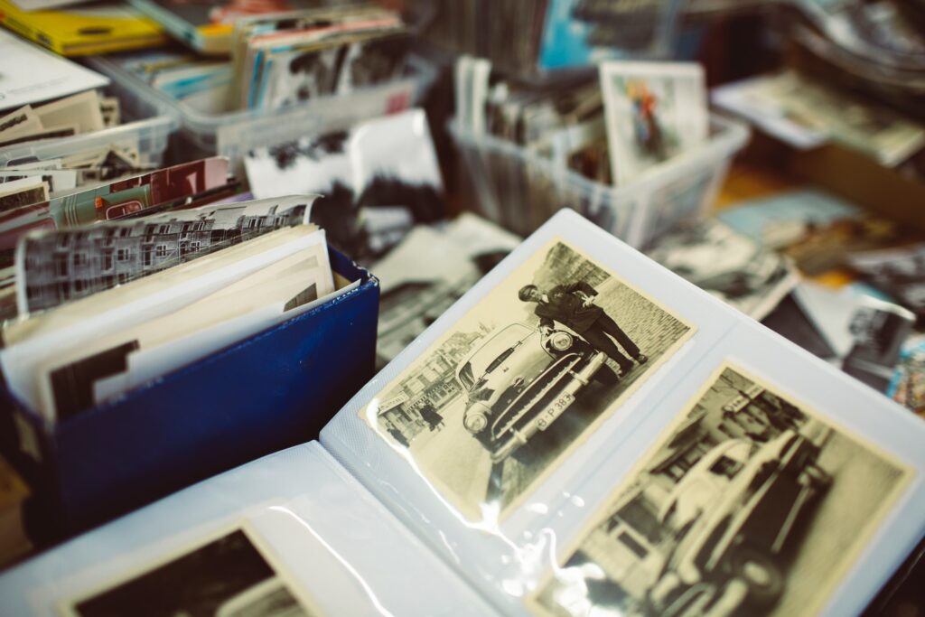 An old photo album on a table covered in boxes of photos