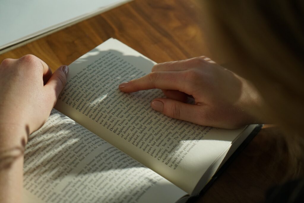 Re-Reading books. Image of person reading a book along with their finger.