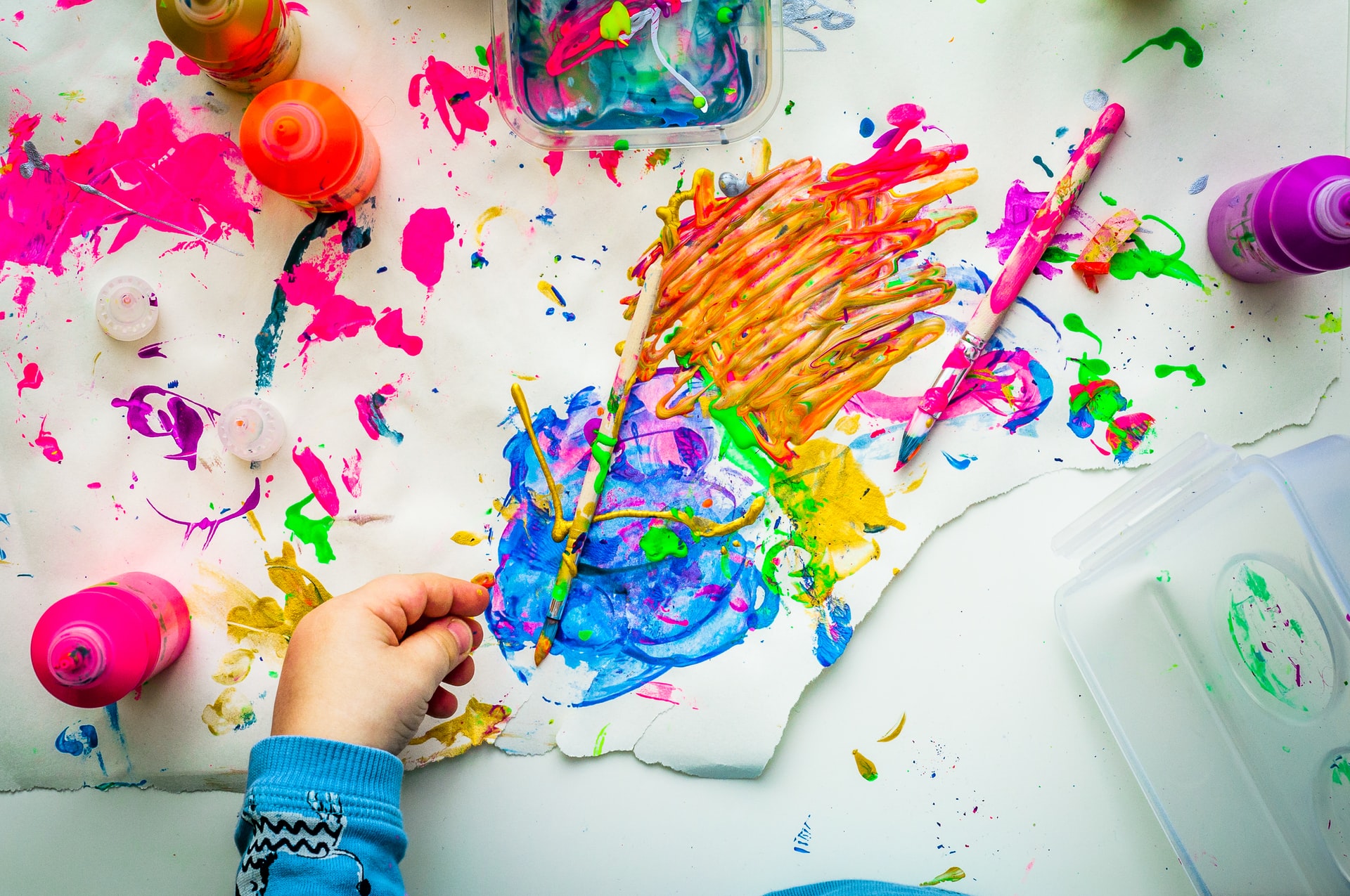 spark your creativity. image of brightly colored finger paints and a child's hand