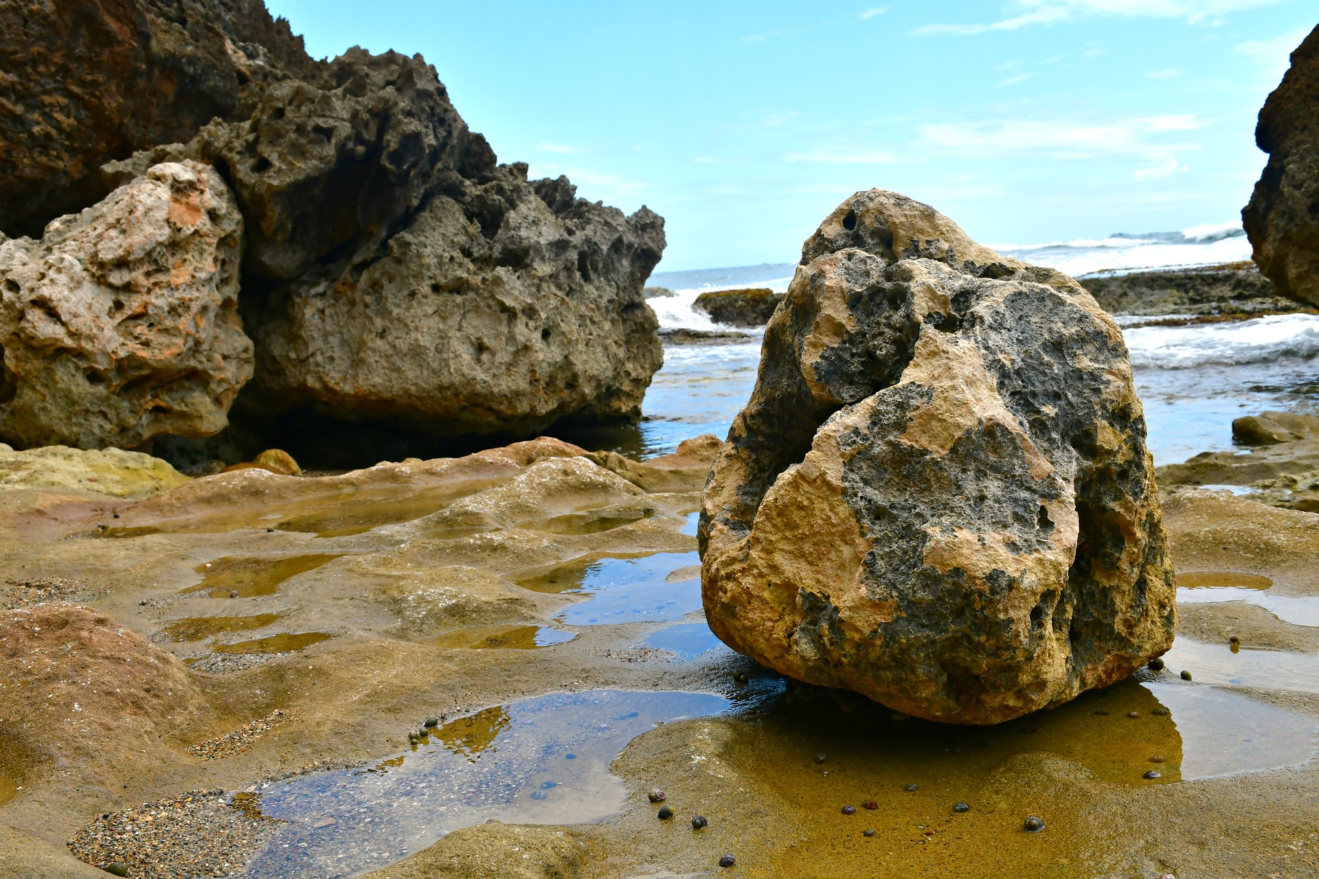 Large rocks on a sandy beach to accompany a blog article by Delia Lloyd about past year reviews.