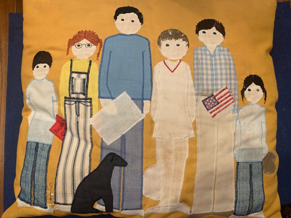 Relearning how to perform family. Photo of a pillow stitched with image of a family